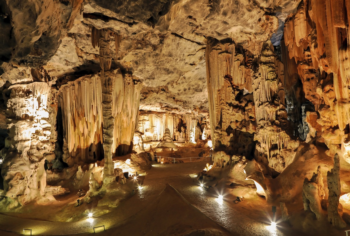 Höhle mit Kalkformationen die stimmungsvoll beleuchtet wird.