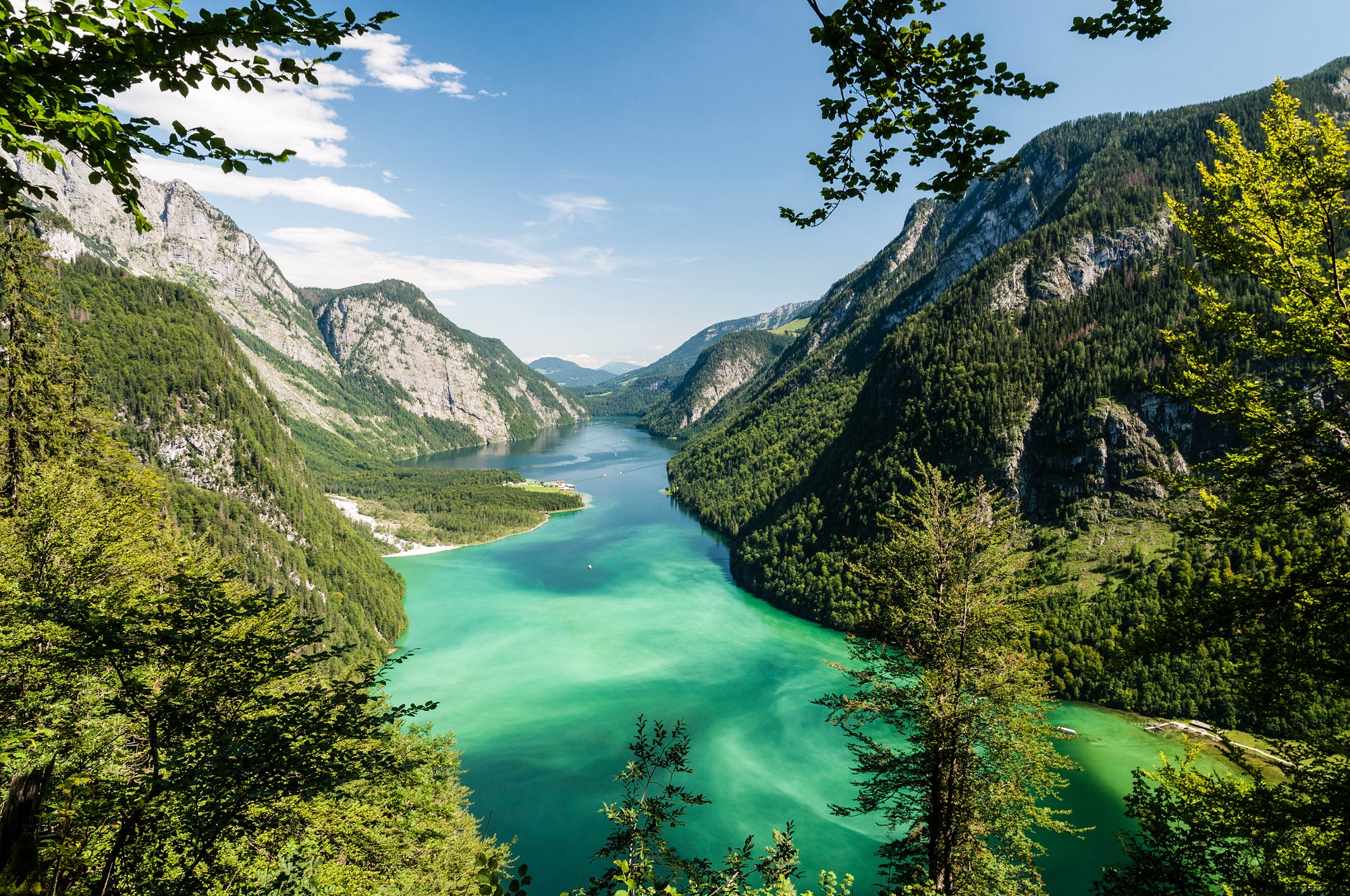 Blick auf den Königssee, der türkis-grün zwischen hohen Bergen liegt.